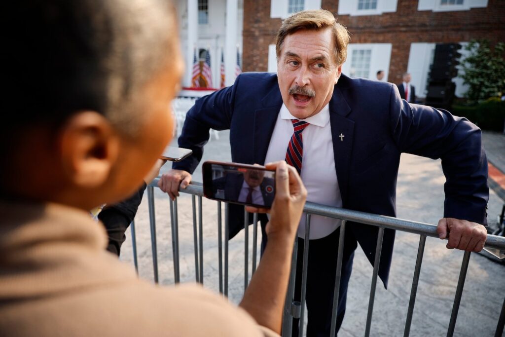 MyPillow CEO Mike Lindell leans against a fence