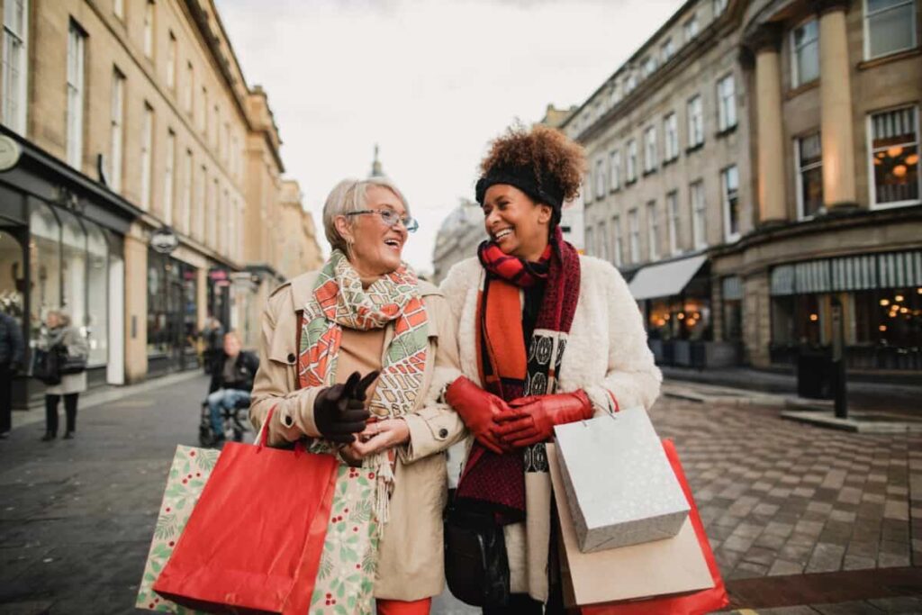 2 insanely cheap shares to consider buying today Two female adult friends walking through the city streets at Christmas. They are talking and smiling as they do some Christmas shopping.
