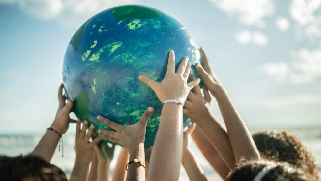 Close-up of children holding a planet at the beach