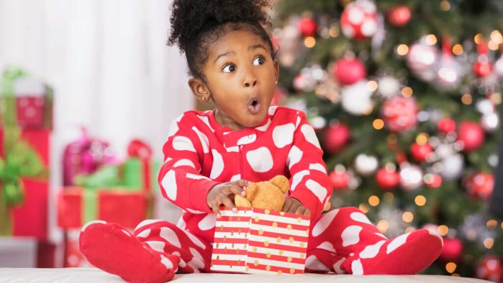 Down 21%, this FTSE 250 stock offers a 10.85% dividend yield for investors Surprised Black girl holding teddy bear toy on Christmas