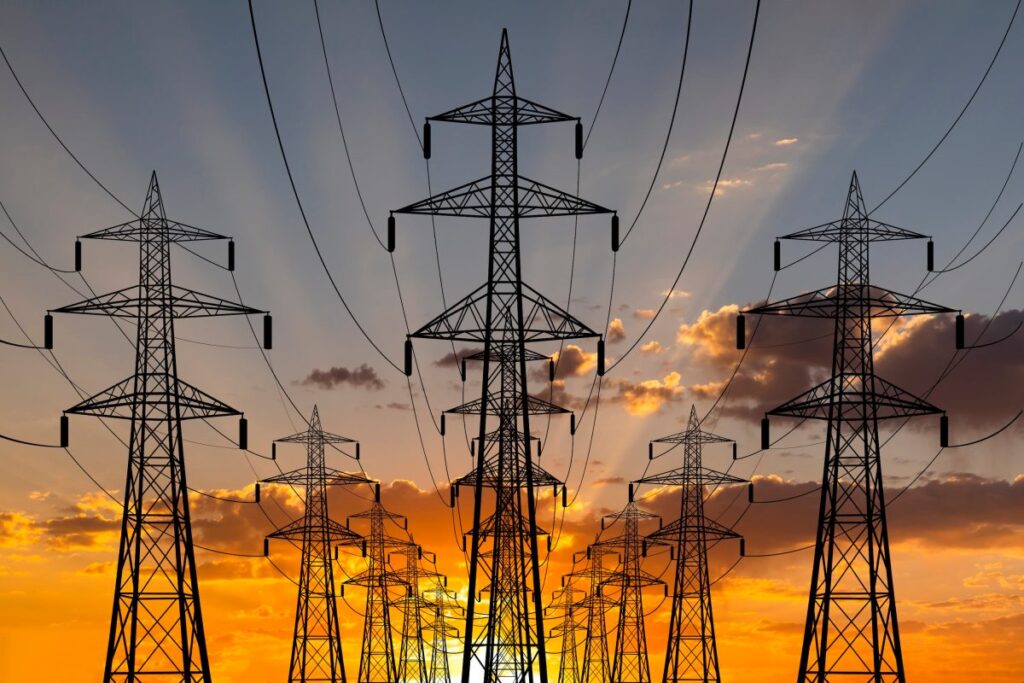 The best AI investment might be in energy tech The sun sets behind transmission lines.