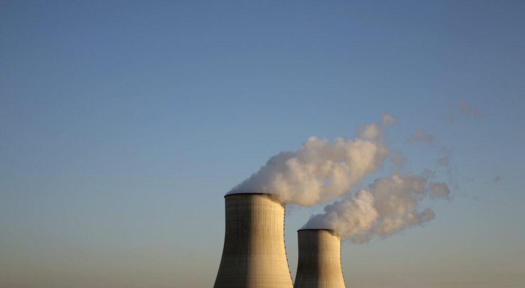Amazon-backed X-energy files to raise up to $800M in IPO Cooling towers for a nuclear reactor stand against a blue sky.