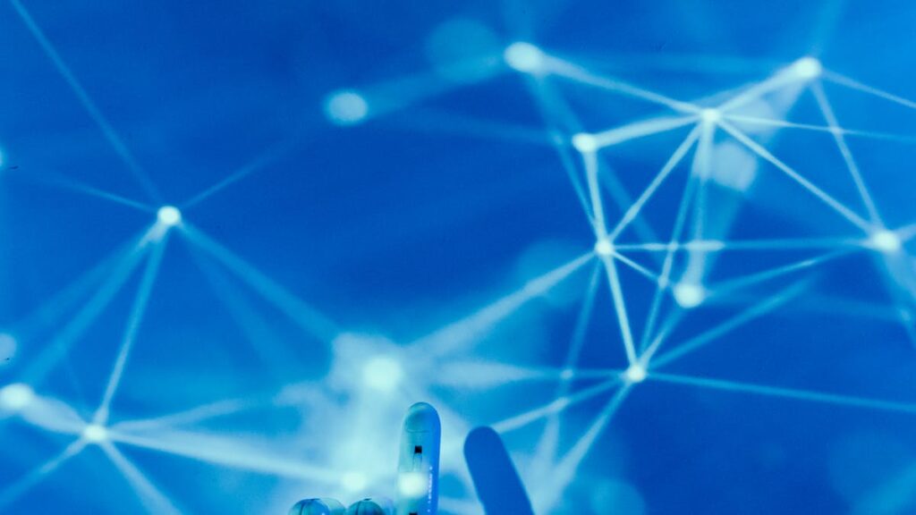 What Is Agentic AI? The 2026 Guide for Business Leaders Robotic hand touching a digital network representing agentic AI