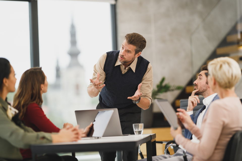 How to Avoid the Common Startup Pitfalls That Can Threaten Your Business A group of entrepreneurs discussing how to avoid common startup pitfalls in a modern office setting