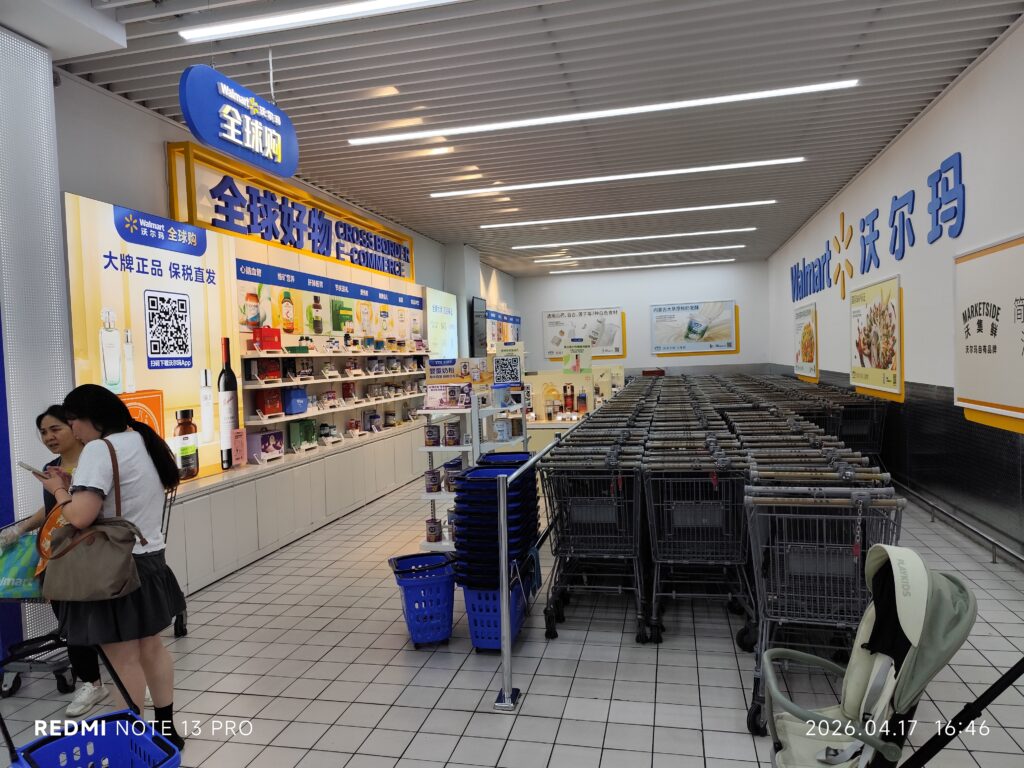 A shopper using a smartphone to look up Costco promo codes in a retail store warehouse