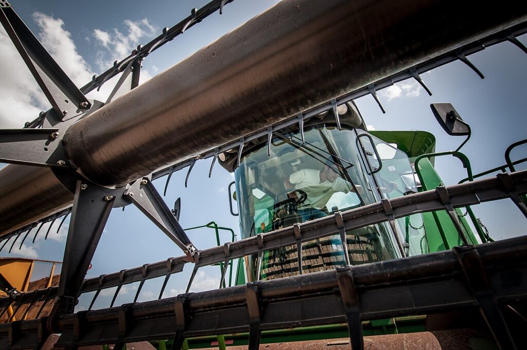 A farmer using agricultural technology AI devices in a modern farm setup